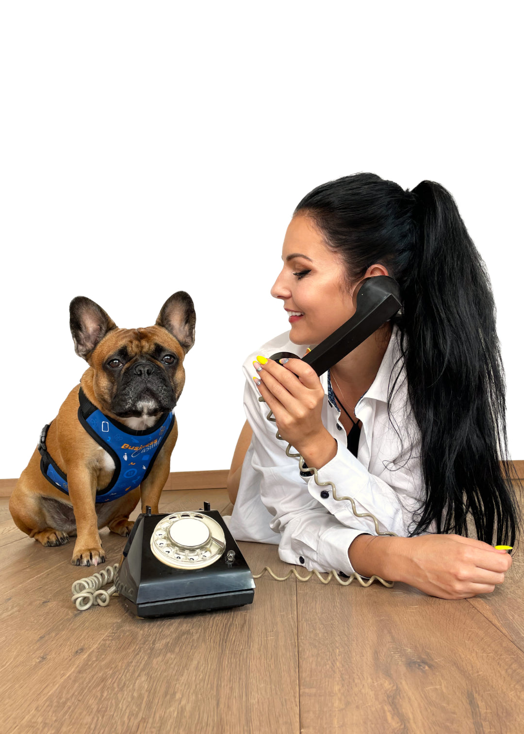 Same setting with circular dialer phone, but both are behind the phone on floor, mom's listening in the phone, looking at Vikcy, while Vicky the frenchie is looking straight into the photo.
